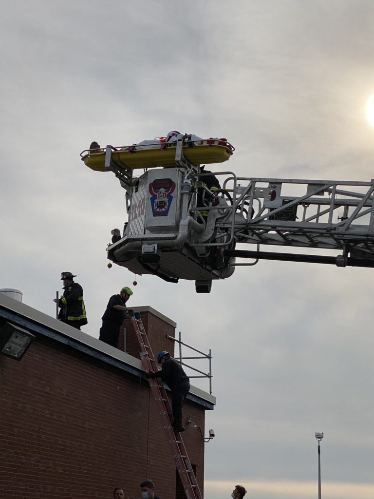 crane carrying victim out of the top of a building