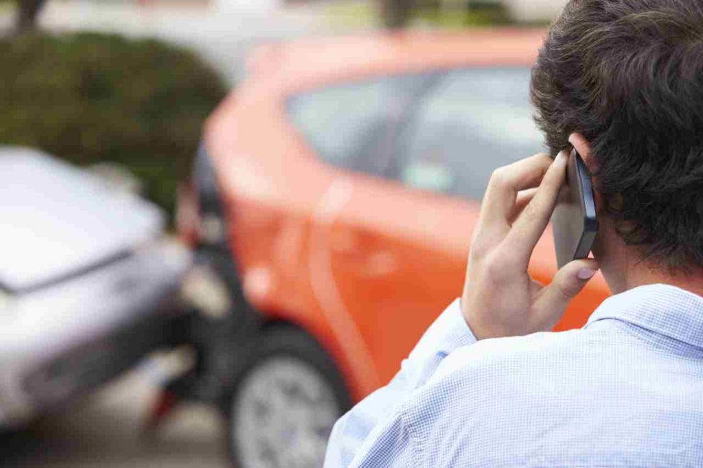 man on cellphone in front of rear end accident