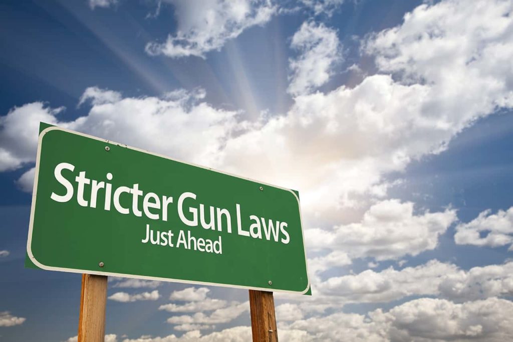 road sign with stricter gun laws just ahead written